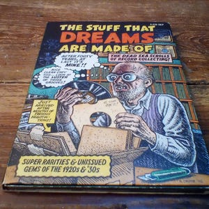 Peut inclure: Une couverture d'album vintage de style bande dessinée intitulée "The Stuff That Dreams Are Made Of". La couverture présente une illustration d'un homme tenant un disque, avec des bulles de texte et la phrase "Super Rarities & Unissued Gems of the 1920s & '30s."