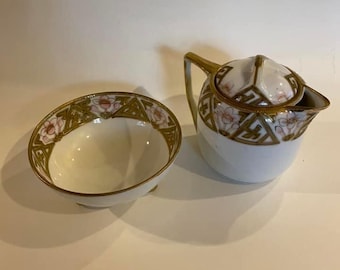 Conjunto antigo de cremeira e açucareiro Nippon, pintado à mão com motivos florais e dourados, marca Moriage com coroa verde, datado de aproximadamente 1891-1921, estilo Art Nouveau, em perfeito estado de conservação.
