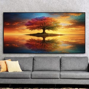 May include: A vibrant landscape painting depicts a colorful tree with a rainbow-hued canopy reflected in calm water. The sky transitions from blue to orange, creating a serene and picturesque scene. The artwork is framed and mounted above a gray sofa.