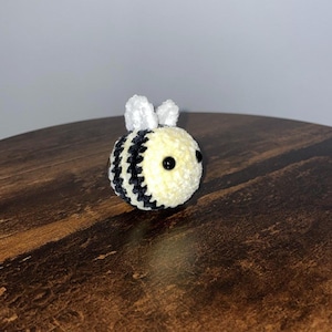 Peut inclure: Un jouet d'abeille au crochet fait &agrave; la main, avec une texture douce et moelleuse. L'abeille a un corps jaune avec des rayures noires, de petites ailes blanches et des yeux en perles noires. Un objet d&eacute;coratif charmant.