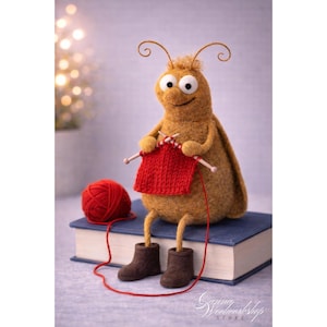 May include: A whimsical, handmade felt bug doll with large eyes and curly antennae, knitting a red square. The doll wears brown boots and sits on a blue book next to a red ball of yarn. The image has a soft, artistic feel.