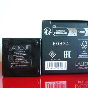 Peut inclure: Un ensemble de flacon et de bo&icirc;te noirs Lalique Eau de Toilette. Le flacon est carr&eacute; avec une &eacute;tiquette indiquant "EAU DE TOILETTE 4,5 ml / 0,15 FL. OZ. / 79 % VOL". La bo&icirc;te porte la mention "LALIQUE BEAUTY".