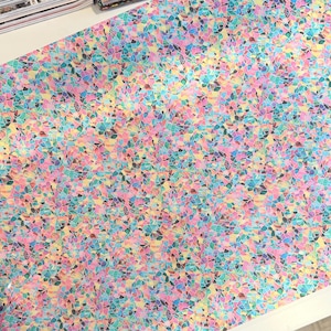 May include: A colorful fabric with a mosaic-like pattern. The design features small, irregular shapes in shades of pink, blue, yellow, and green. The overall effect is a vibrant and textured surface, suitable for various craft projects.