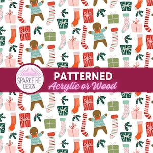 May include: A repeating pattern on a white background featuring gingerbread people in blue sweaters, red and white striped stockings, pink and green gift boxes with bows, and holly sprigs. A purple banner across the center reads SPARKFIRE DESIGN PATTERNED Acrylic or Wood.