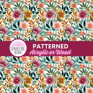 Peut inclure: Un motif floral avec des fleurs à l'aquarelle dans les tons de rose, d'orange et de jaune, avec des feuilles vertes et dorées. Le design comprend le texte "PATTERNED Acrylic or Wood" en blanc sur une bannière bordeaux. Le logo Sparkfire Design est également présent.