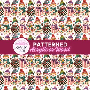 May include: A repeating pattern of colorful snowmen on a white background with small star and snowflake accents. A dark pink horizontal band across the center displays the white text Sparkfire Design Patterned Acrylic or Wood.