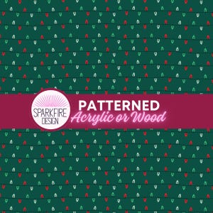 May include: A dark green sheet featuring a repeating pattern of thin black horizontal lines with small red, white, and green Christmas light bulbs. A circular logo reads SPARKFIRE DESIGN with the text PATTERNED Acrylic or Wood.