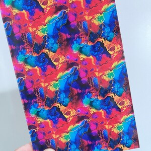 May include: A rectangular sheet with a vibrant, abstract pattern. The design features a mix of red, blue, yellow, and purple hues with gold-colored vein-like accents. The overall effect is a colorful, fluid, and artistic design.
