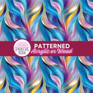 May include: A repeating pattern of flowing, abstract waves in shades of blue, pink, and gold. A horizontal maroon banner across the center features a circular logo with the text SPARKFIRE DESIGN and the words PATTERNED Acrylic or Wood.