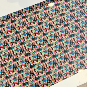 May include: A sheet of patterned paper featuring a repeating design of colorful floral arrangements and abstract shapes. The design includes a variety of colors, including pink, blue, green, and black, arranged in a grid-like pattern.