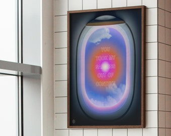 May include: A framed print with a colorful, abstract design. The design features a circular shape with a gradient of pink, orange, and yellow colors. The text "YOU TOOK MY SADNESS OUT OF CONTEXT" is written in neon pink letters inside the circle.