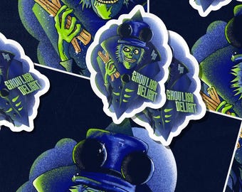 May include: A repeating pattern of stickers featuring a green-skinned ghoul in a blue top hat and coat, holding wooden sticks. The stickers have the text "Ghoulish Delight" in white. The background is a dark blue.