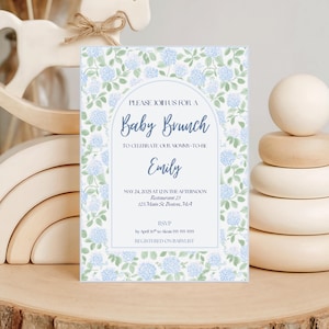 May include: A baby brunch invitation with a floral design in blue and green. The invitation includes the text "Baby Brunch" and details for the event, including the name "Emily" and the date and time.