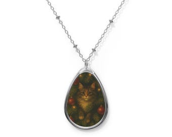 May include: Silver-toned necklace with a teardrop pendant featuring a cat nestled among Christmas tree branches and red ornaments. The cat has brown and tan fur. The pendant is approximately 1.5 inches long.