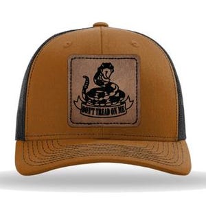 May include: A brown and black trucker hat with a brown leather patch featuring a rattlesnake and the text "Don't Tread On Me".