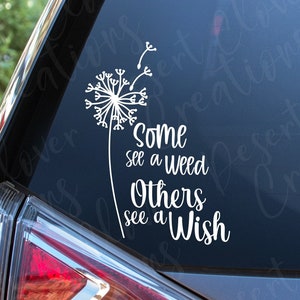 May include: White vinyl decal with a dandelion and the text "Some see a weed Others see a Wish" on a car window.