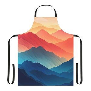 May include: An apron with a colorful mountain range design. The mountains are a gradient of orange, red, blue, and purple. The apron has black adjustable straps.