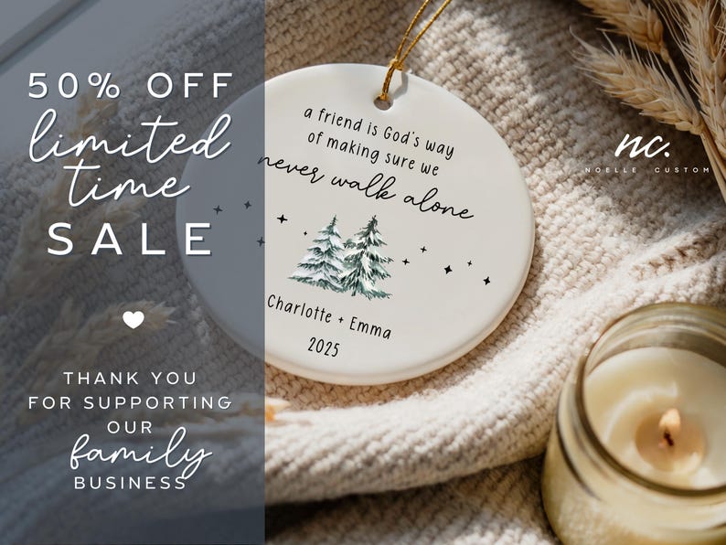 May include: A round white ceramic ornament featuring a gold hanging string. The text reads: a friend is God's way of making sure we never walk alone, Charlotte + Emma, and 2025. It includes a graphic of two green pine trees and small black stars.
