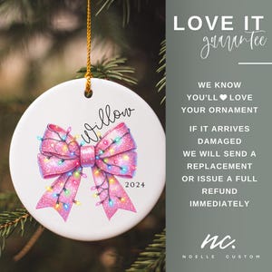 May include: A white ceramic Christmas ornament with a pink bow decorated with colorful lights. The ornament has the name "Willow" and the year "2024" written on it. The ornament is hanging from a gold string.