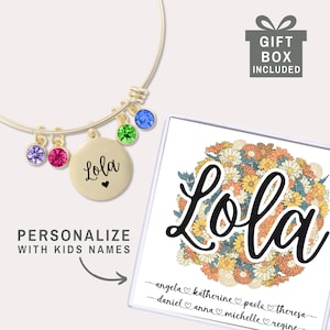May include: A gold-colored bangle bracelet with colorful gemstone charms and a round pendant engraved with the name "Lola" and a heart. A gift box with the text "Gift Box Included" is also shown. The text "Personalize with Kids Names" is also shown.