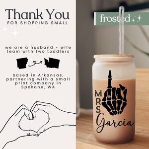 May include: A frosted glass tumbler with a straw, featuring a black skeleton hand with a ring on the middle finger, and the text "MRS Garcia". The tumbler is filled with a brown liquid.