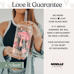 May include: A clear glass mug with a pink mushroom and floral design. The mug has a bamboo lid and a reusable straw. The text "Love it Guarantee" and "++clear" are visible in the image.