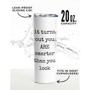 May include: White stainless steel tumbler with a blue lid and a black and white typewriter font saying "it turns out you are smarter than you look". The tumbler is 20 ounces and has a leak-proof sliding lid. It fits in most cupholders.