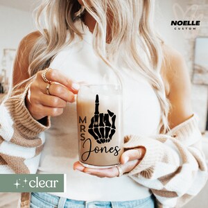May include: A clear glass tumbler with a black skeleton hand design and the text "MRS Jones".