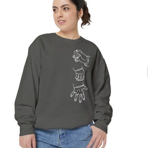 May include: A charcoal gray sweatshirt with a white outline of three hands in a gesture of support.