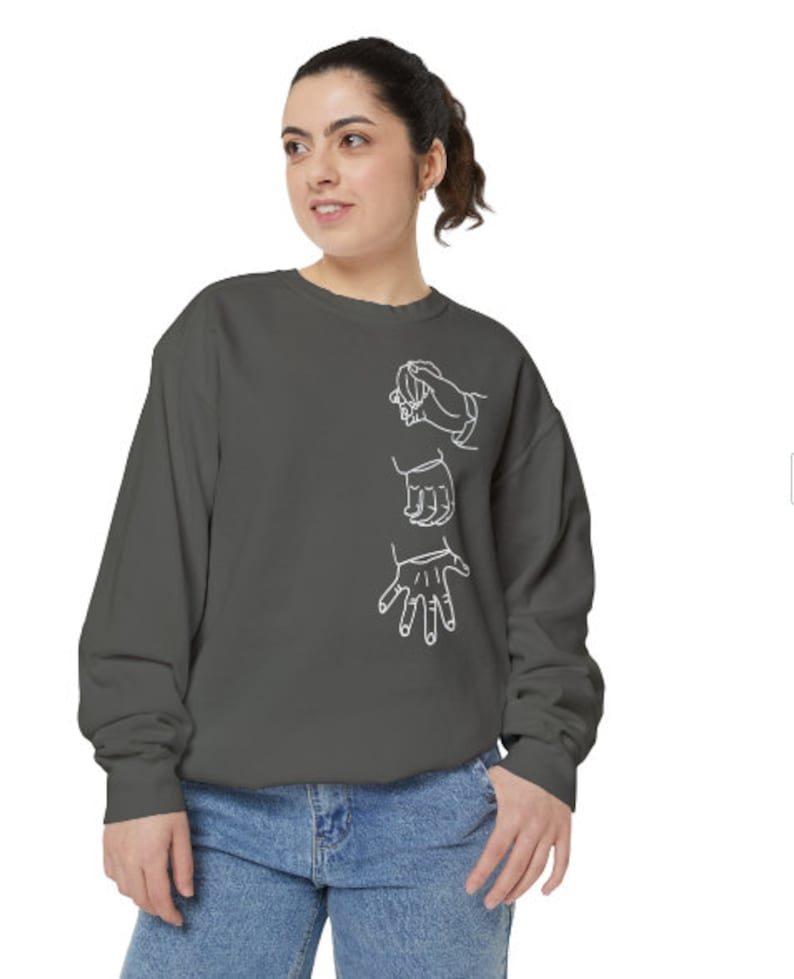 May include: A charcoal gray sweatshirt with a white outline of three hands in a gesture of support.