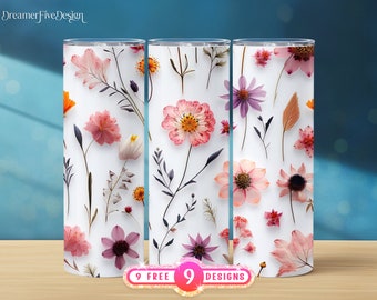 Puede incluir: Tres vasos blancos con un diseño floral con flores prensadas en tonos rosa, morado y naranja. Los vasos están sobre una superficie azul claro.