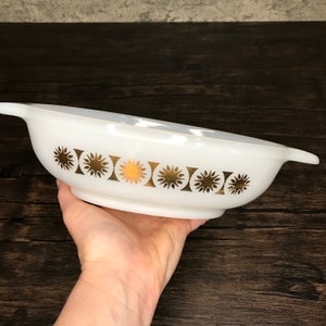 Peut inclure: Plat à four ovale blanc avec un motif de soleil doré autour du bord.