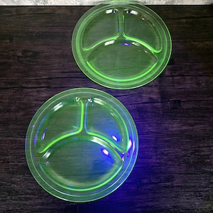 May include: Two vintage green uranium glass divided plates. The plates are divided into three sections and have a bright green colour.