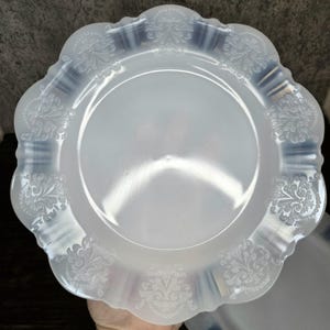 Puede incluir: Plato de plástico blanco con borde festoneado y diseño floral en relieve.