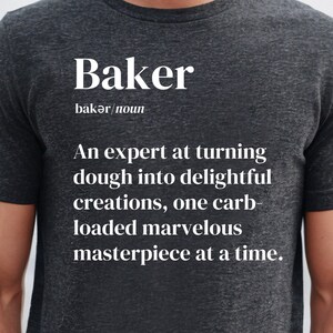 Peut inclure: T-shirt gris foncé avec le mot "Baker" et sa prononciation phonétique en blanc. Le t-shirt définit un boulanger comme un expert pour transformer la pâte en créations délicieuses, un chef-d'œuvre chargé de glucides à la fois.