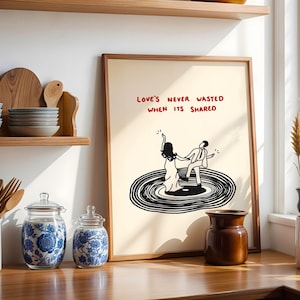 Pode incluir: Uma impress&atilde;o art&iacute;stica emoldurada com fundo creme, apresentando um desenho de linha preta de duas figuras dan&ccedil;ando em um disco de vinil. O texto acima das figuras diz "LOVE'S NEVER WASTED WHEN ITS SHARED" em letras vermelhas manuscritas.