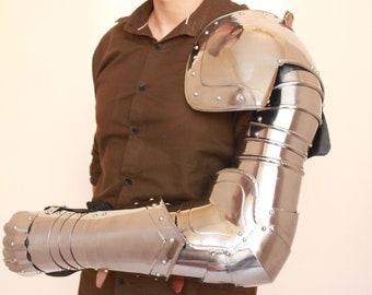 May include: A silver metal arm armor with a gauntlet, elbow, and shoulder piece. The armor is made of metal plates and has a shiny finish.