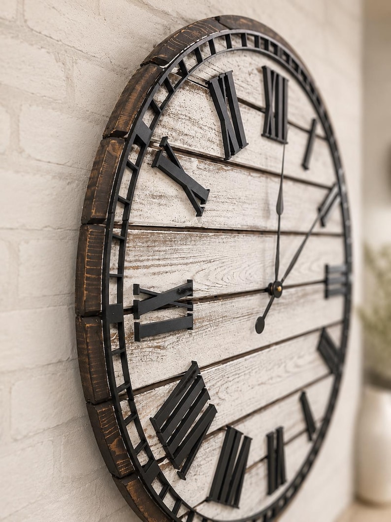 K&ouml;nnte beinhalten: Eine gro&szlig;e, runde Wanduhr mit rustikalem Design. Die Uhr hat ein wei&szlig;es Holzgesicht mit schwarzen r&ouml;mischen Ziffern und Zeigern. Der &auml;u&szlig;ere Rahmen ist dunkelbraun, und die Uhr ist an einer wei&szlig;en Backsteinmauer befestigt.