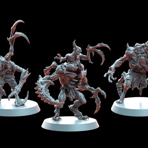 以下が含まれることがあります： 鋭い爪と歯を持つ、怪物のような生き物のグレーのミニチュアフィギュア3体。フィギュアは丸い台座の上に置かれています。