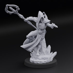 May include: A gray figurine of a robed figure with a staff, poised in a dynamic stance. The figure is on a rocky base, with a dark circular base. The figure is wearing a hooded cloak and armor.