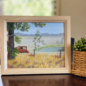 May include: A framed painting of a red truck parked in a field with a pond and trees in the background. The painting is signed "J. Winterburn".