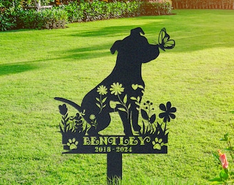 May include: Black metal silhouette of a dog with a butterfly on its nose, surrounded by flowers. The dog is sitting on a base with the text "Bentley 2018-2024" and paw prints.