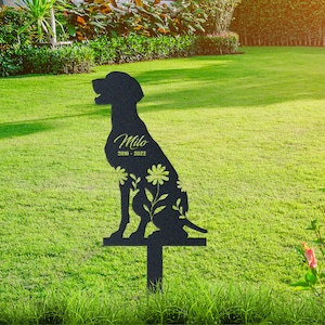 May include: Black metal silhouette of a dog with floral accents, a memorial garden stake with the name "Milo" and the dates "2010 - 2022".