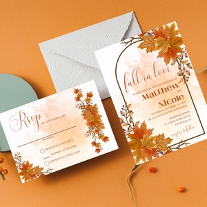 May include: Fall wedding invitation with a watercolor background and autumn leaves. The invitation reads "Fall in love" and includes the names Matthew and Nicole, the date and time of the wedding, and the location. The RSVP card includes a watercolor background with autumn leaves and a space for guests to RSVP by September 2021.
