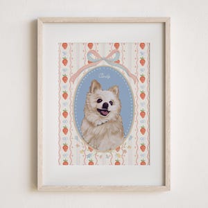 May include: A framed portrait of a fluffy, light-colored dog with a happy expression. The dog is centered in an oval frame against a blue background, with the name "Candy" above. The background features a strawberry and ribbon pattern.