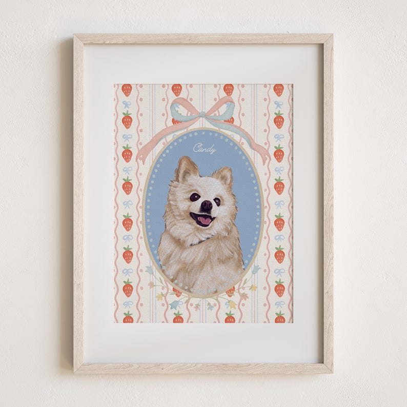 May include: A framed portrait of a fluffy, light-colored dog with a happy expression. The dog is centered in an oval frame against a blue background, with the name "Candy" above. The background features a strawberry and ribbon pattern.