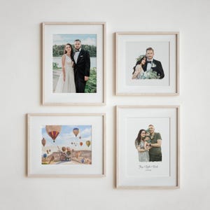 Może przedstawiać: Cztery oprawione zdjęcia na białej ścianie. Zdjęcie w lewym g&oacute;rnym rogu przedstawia parę w strojach ślubnych stojącą przed jeziorem. Zdjęcie w prawym g&oacute;rnym rogu przedstawia parę w strojach ślubnych stojącą przed zielonym tłem. Zdjęcie w lewym dolnym rogu przedstawia scenę z balonami na gorące powietrze. Zdjęcie w prawym dolnym rogu przedstawia rodzinę trzyosobową stojącą przed zielonym tłem. Zdjęcie zawiera tekst "Ange & Sophie & Noah" i "20.11.2021".