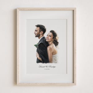 May include: A framed watercolour portrait of a couple embracing. The man wears a black suit, and the woman wears a white dress. The artwork is signed "Daniel & Penelope" with the date "21.04.2024" below the names. The frame is light-coloured wood.