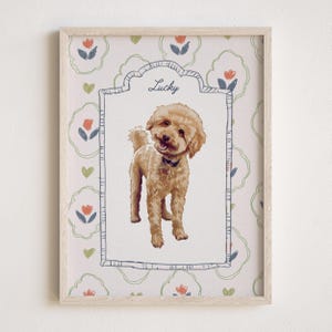 May include: A framed print featuring a tan poodle with the name "Lucky" above the dog. The background has a floral pattern with red, blue, and green accents. The frame is light wood.