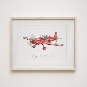 Op de afbeelding: Een ingelijste print met een illustratie van een rood vliegtuig. Het vliegtuig heeft een propeller en staat tegen een witte achtergrond. De tekst "Happy Birthday Opa" staat eronder in cursief.